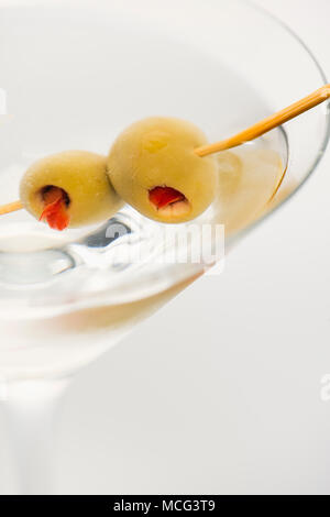 A close up of a dirty martini with olives.