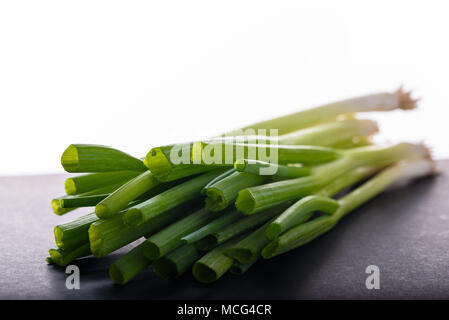 A bundle of fresh green onions on a dark surface with white copy space, bunch of escallion Stock Photo