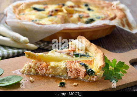 Baked quiche with fresh white asparagus, smoked salmon and spinach Stock Photo