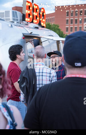 Friends gathering near a BBQ food truck at the Creative South bridge party on the Pedestrian Bridge spanning the Chattahoochee River in Columbus, GA. Stock Photo