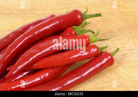 Red chili peppers on a chopping board. Stock Photo