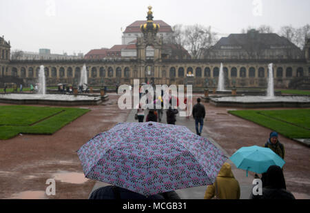 16 April 2018, Germany, Dresden: Tourists with umbrellas in the rain in the courtyard of the Zwinger palace. Photo: Monika Skolimowska/dpa-Zentralbild/ZB Stock Photo