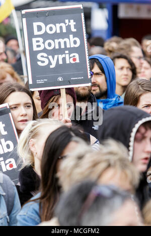 Bristol, UK. 16th April, 2018. Protesters carrying ‘Don’t bomb Syria’ placards are pictured as they listen to speeches during a Stop Bombing Syria protest march and rally.  The rally and march was organised by the Bristol Stop the War Coalition to protest against the UK governments airstrikes in Syria. Credit: lynchpics/Alamy Live News Stock Photo