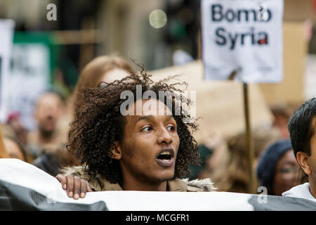 Bristol, UK. 16th April, 2018. Protesters are pictured as they march through Bristol during a Stop Bombing Syria protest march.  The rally and march was organised by the Bristol Stop the War Coalition to protest against the UK governments airstrikes in Syria. Credit: lynchpics/Alamy Live News Stock Photo