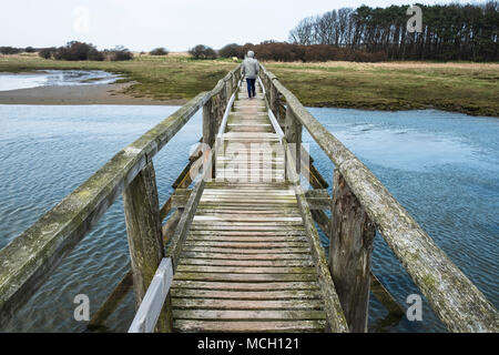 View of wooden footbridge leading to Aberlady Bay Nature Reserve on coast of Firth of Forth estuary in East Lothian, Scotland, UK Stock Photo