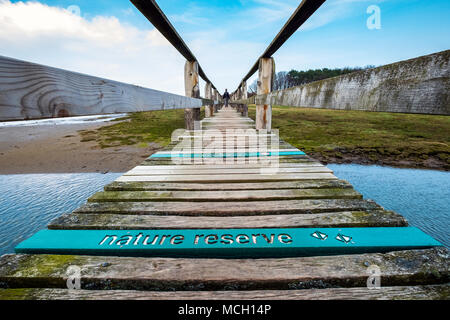 View of wooden footbridge leading to Aberlady Bay Nature Reserve on coast of Firth of Forth estuary in East Lothian, Scotland, UK Stock Photo