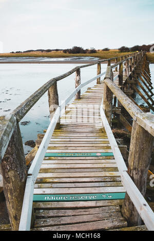 View of wooden footbridge leading to Aberlady Bay Nature Reserve on coast of Firth of Forth estuary in East Lothian, Scotland, UK Stock Photo