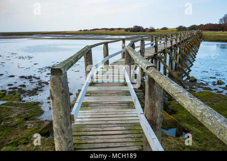 View of wooden footbridge leading to Aberlady Bay Nature Reserve on coast of Firth of Forth estuary in East Lothian, Scotland, UK Stock Photo