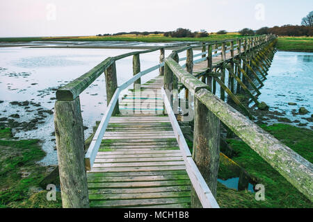 View of wooden footbridge leading to Aberlady Bay Nature Reserve on coast of Firth of Forth estuary in East Lothian, Scotland, UK Stock Photo