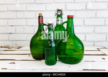 Vintage green glass bottles on an old white washed table Stock Photo