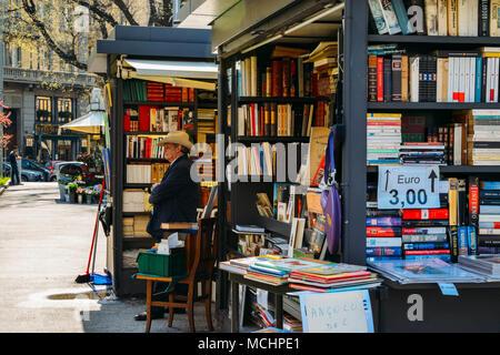 Milan, Italy - April 14, 2018: An older man with a cowboy hat sells books on the street Stock Photo