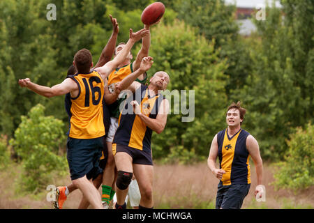 Roswell, GA, USA - May 17, 2014:  Several players jump to catch ball in an amateur club game of Australian Rules Football in a Roswell city park. Stock Photo