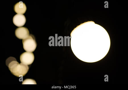 Soft bokeh background. Garland of electric lights. Place to add text. Blurry abstraction. Black & white. Dark night. Festive party in city. Soft focus Stock Photo