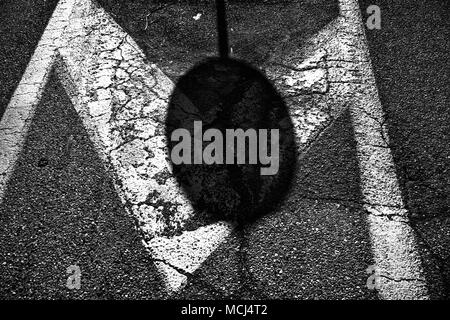 Shadow street sign on asphalt road, urban background. Stock Photo