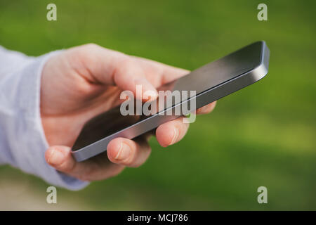 Woman using smartphone outdoors, close up of hand Stock Photo