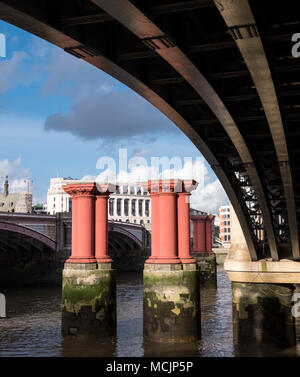 London UK. View of Blackfriars Bridge over the River Thames from underneath, and the support pillars belonging to the old bridge. Stock Photo