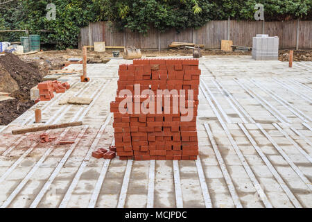 A pile of new bricks at construction site sitting on pallet Stock Photo ...