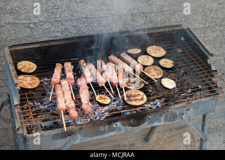 Meat kebab and eggplant being cooked on barbecue grill, Heraklion, Greece Stock Photo