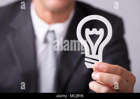 Close-up Of A Businessperson's Hand Holding White Lightbulb Stock Photo