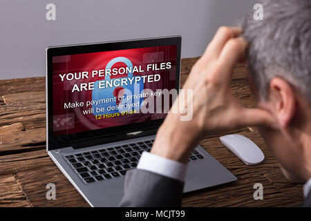Close-up Of A Businessperson Looking At Laptop Screen Showing Personal Files Encrypted Text Stock Photo