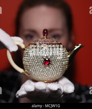 A member of the curatorial team shows off The Egoist in London, ahead of National Tea Day. Named by Guinness World Records in 2016 as the world's most valuable teapot at 3 million US Dollars (&pound;2,307,900), it was designed by Nirmal Sethia, Chairman of Newby Teas, and inspired by his late wife Chitra, who passed away in 2010. Stock Photo