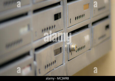 Silver mailbox with locker in focus. Locker on a metal mailbox Stock Photo