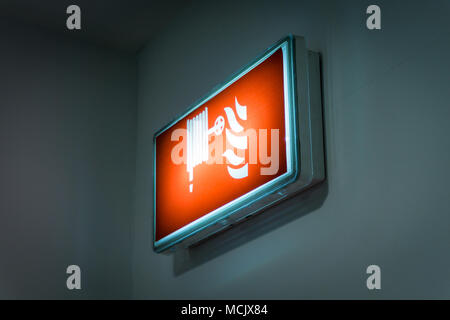 Fire hose reel sign on a wall. Fire hose symbol on a lightbox Stock Photo
