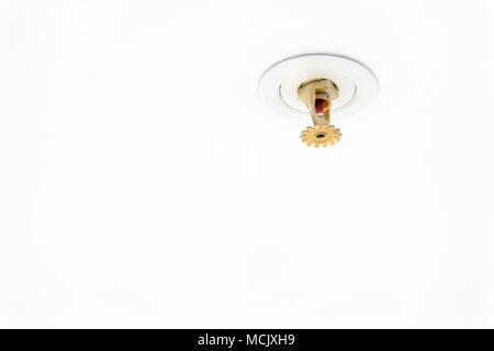 Close up image of fire sprinkler on white. Fire sprinklers are part of an integrated water piping system designed for life and fire safety. Automatic Stock Photo