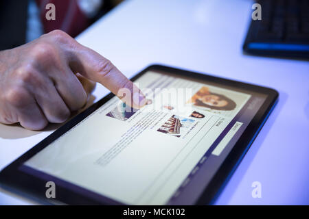 Close-up Of A Businessperson's Hand Using Social Networking Site On Digital Tablet Stock Photo