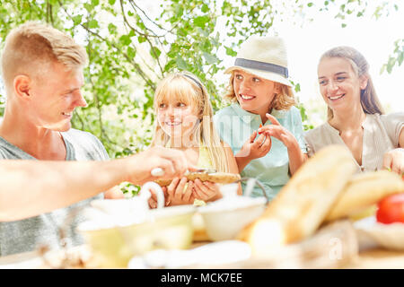 Happy family and children together having breakfast in the garden Stock Photo