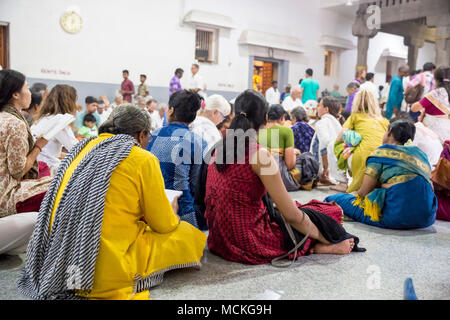 Ashram of Sri Ramana Maharshi, Tiruvannamalai, Tamil Nadu, India - March circa, 2018. Unidentified woman and man sitting on the floor of ashram Stock Photo