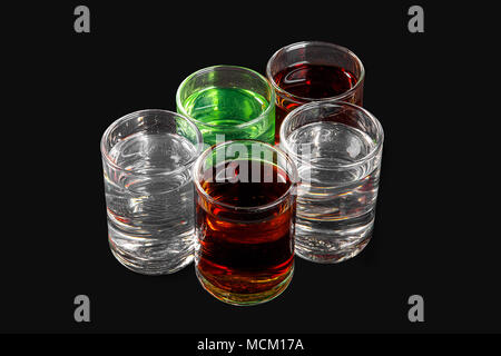 Multicolored transparent cocktails, a set of shots in a heap, a wedge, five servings. Side view from above Isolated black background. Drink for the me Stock Photo