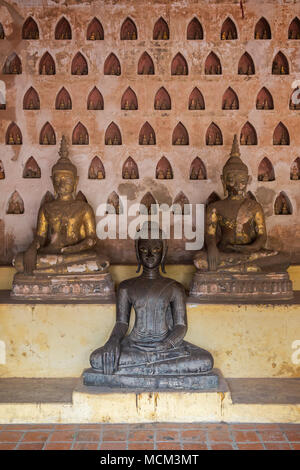 Front view of three old and aged Buddha statues at the Wat Si Saket (Sisaket) temple's cloister in Vientiane, Laos. Stock Photo