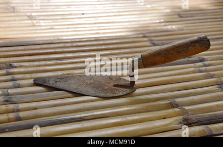 steel trowel on bamboo Stock Photo