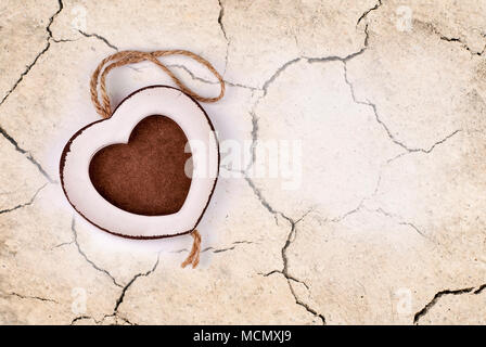 Photo frame in wood heart shape on dry cracked earth background Stock Photo