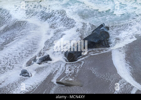 The sea flowing around a rock on the beach at Little Fistral in Newquay Cornwall. Stock Photo
