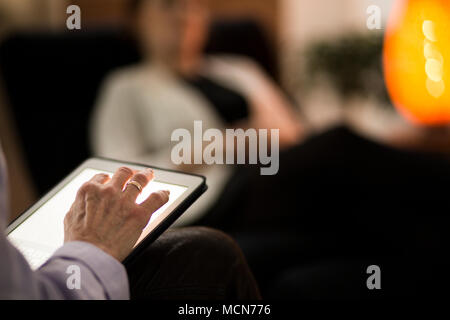 Woman's hand with a wedding ring writing on a tablet during a psychotherapy Stock Photo