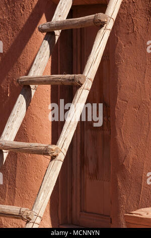 Wooden ladder leaning against adobe wall Stock Photo