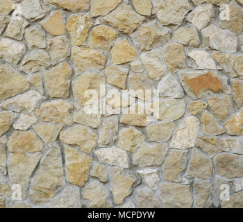 Old yellow stone pavement texture. Ancient natural cobblestone road as background. Abstract background of old cobblestone pavement. Stock Photo