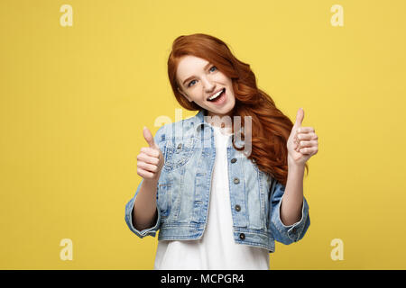 Lifestyle Concept: Happy excited cuacaisan tourist girl pointing finger on copy space isolated on golden yellow background Stock Photo