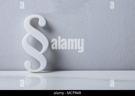 Close-up Of A Paragraph Symbol Leaning On White Wall
