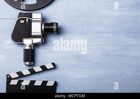 High Angle View Of Movie Camera With Film Reel And Clapper Board On Wooden Plank Stock Photo