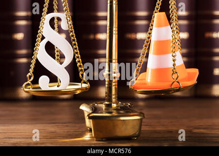 Close-up Of White Paragraph Symbol And Traffic Cone On Justice Scale In Courtroom Stock Photo