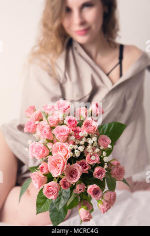 Woman Holds Out a Bouquet Wrapped in Black Paper, Covering Her