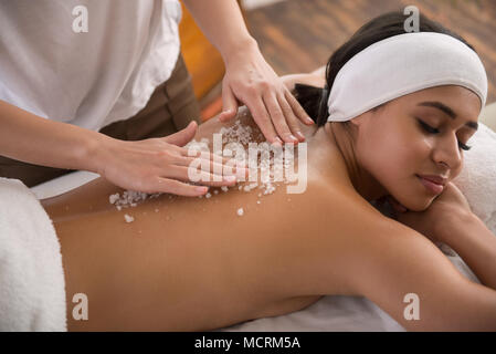Beautiful young woman enjoying the massage Stock Photo