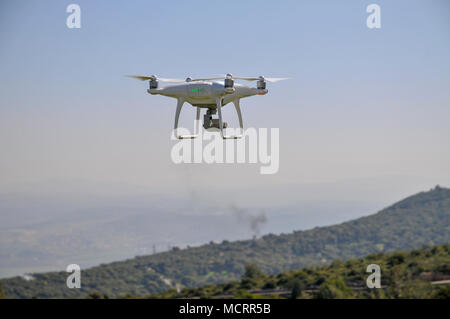 Remote control Quadrocopter, drone, with camera flying against a blue sky Stock Photo