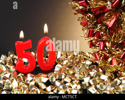 Birthday-anniversary candle showing Nr. 50  Lit red candle good for an anniversary or birthday background. Stock Photo