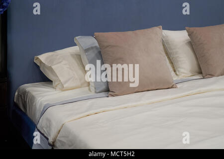 New comfortable double bed with beige pillows Stock Photo