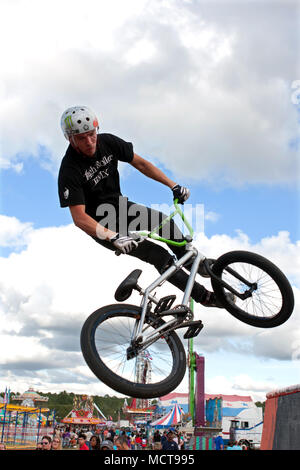 A young man with the High Roller BMX club spins his bike while performing a BMX stunt at the Georgia State Fair on September 27, 2014 in Hampton, GA. Stock Photo