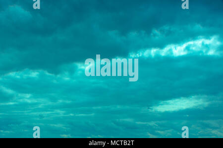 Despite dark clouds, on the blue sky  sun shines. Stock Photo